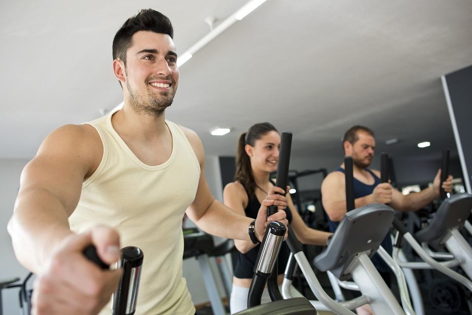 People at gym on elliptical machine