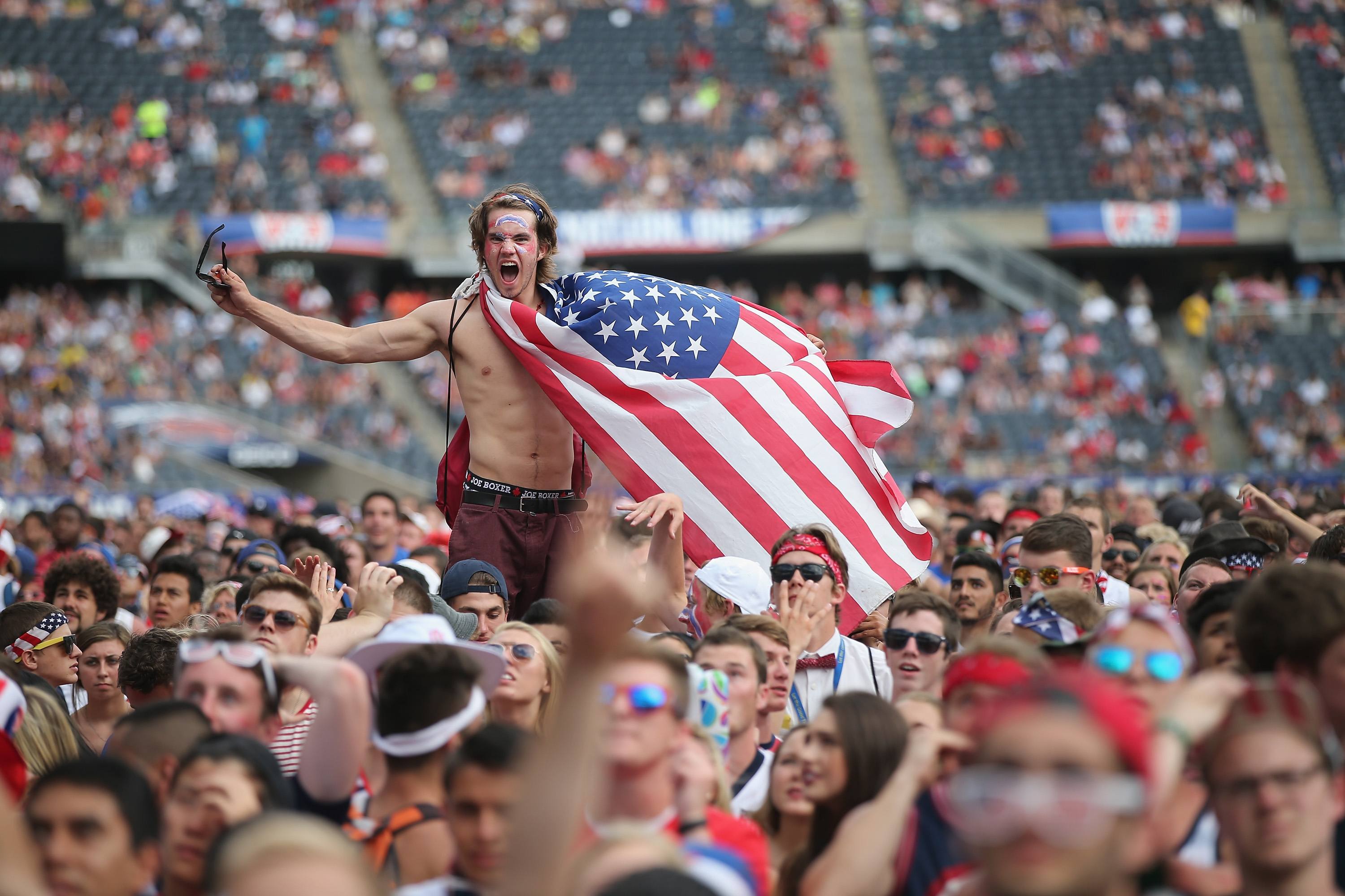 An American soccer fan, draped in a flag