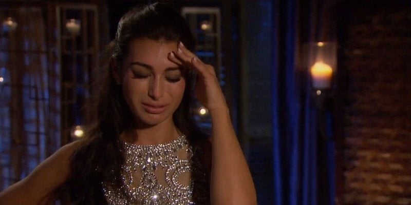 A woman cries and holds her forehead in 'The Bachelor'.