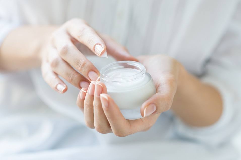 Hands applying moisturizer Hands applying moisturizer