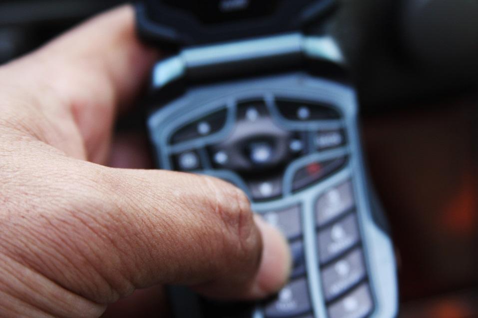 Male dialing a number on a celluar device Male dialing a number on a celluar device