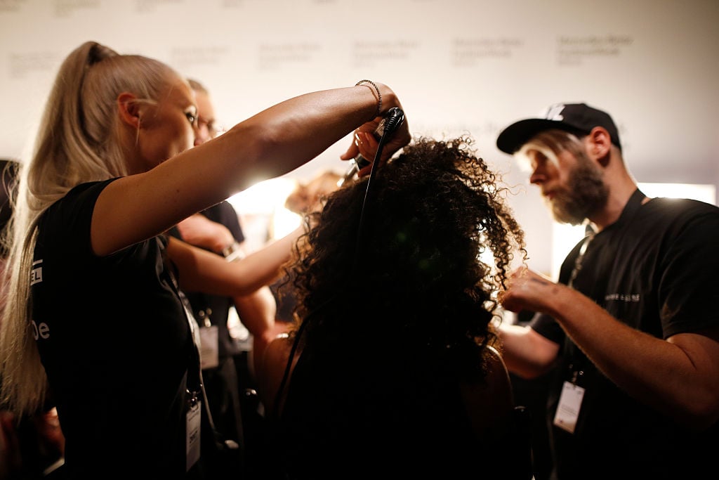 A model is getting her hair done backstage ahead of the Dimitri show during the Mercedes-Benz Fashion Week