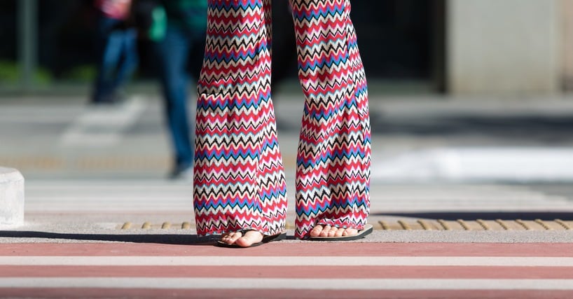 girl crossing the street with rubber sandals and flare pants