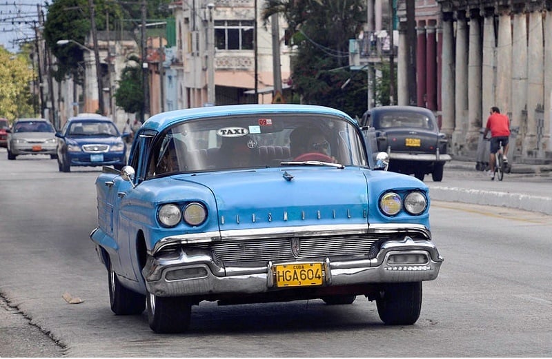 A private taxi (Oldsmobile Super 88, circa 1958) drives along a street on