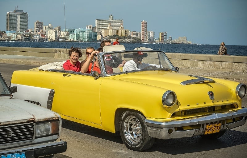 Tourist take a ride in a fully restored Mercury along the coast in Havana on March 18, 2013. Luxury is slowly reappearing in Cuban society after half a century of egalitarianism and austerity, brought upon by the economic reforms of Cuban President Raul Castro.