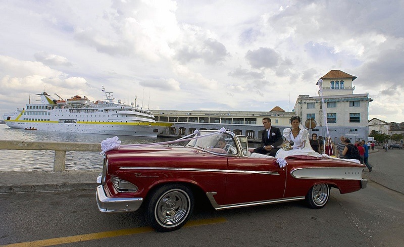 A Cuban just married couple ride in a Ford Edsel 58 near the waterfront in Havana, on February 23, 2008. Cuba's National Assembly was to select Sunday a successor to Fidel Castro, likely his brother Raul Castro, extending the Americas' only communist one-party regime in defiance of US-led calls for political opening. Fidel Castro lashed out at Western appeals for democracy in the days leading up to the vote, which will trigger some readjustments in the political chessboard even as the transition bears the exiting leader's imprint. Saturday, Fidel Castro wrote in another editorial that he was eagerly awaiting the "transcendental decision" of the National Assembly, and took a potshot at the US-based Organization of American States which does not allow Cuba to be a member due to its lack of democracy.