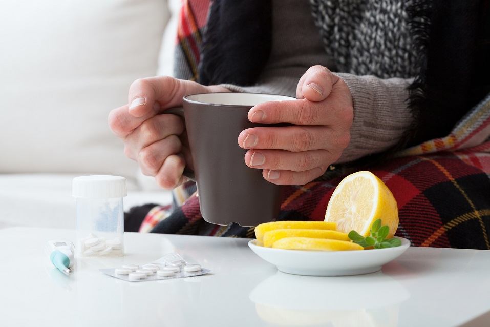 Ill man holding hot drink