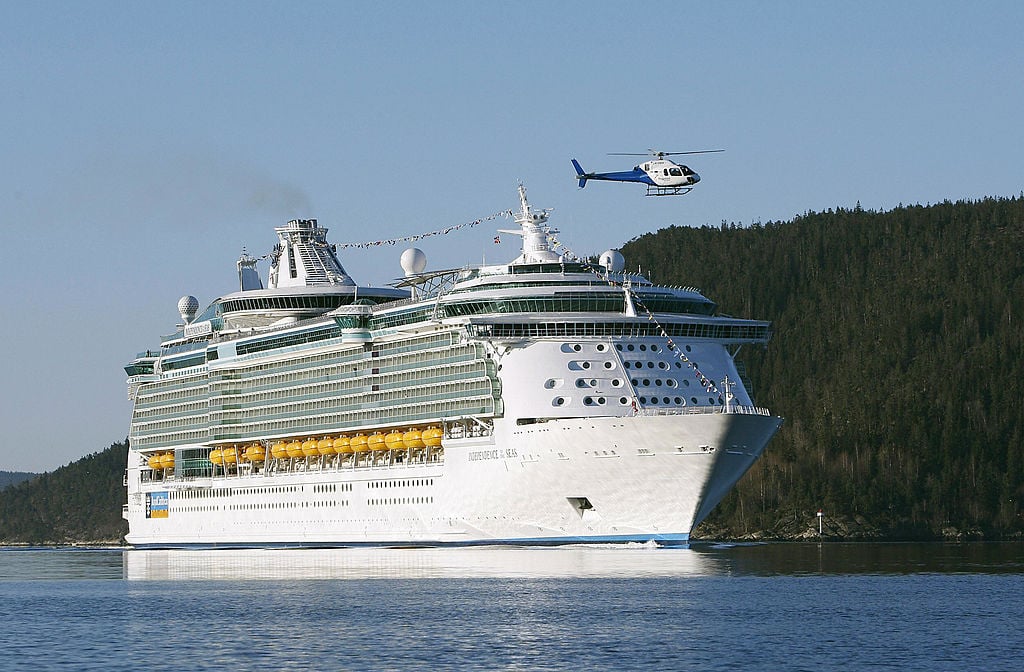 A helicopter flies over the Independence of the Seas cruise liner