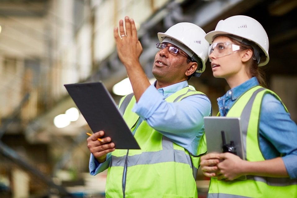 two men in hard hats and vests