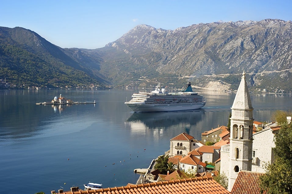 A cruise liner sails by Our Lady of the Rocks off the coast of Montenegro