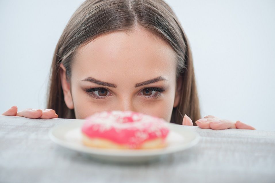 woman looking at doughnut