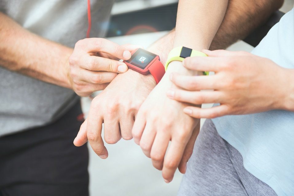 Active and sporty couple looking at their smartwatches