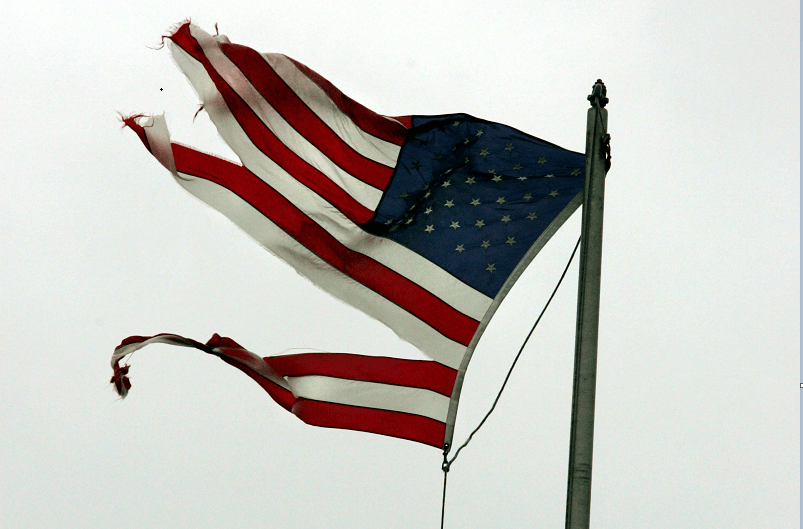 A tattered American flag signifies the broken American dream.