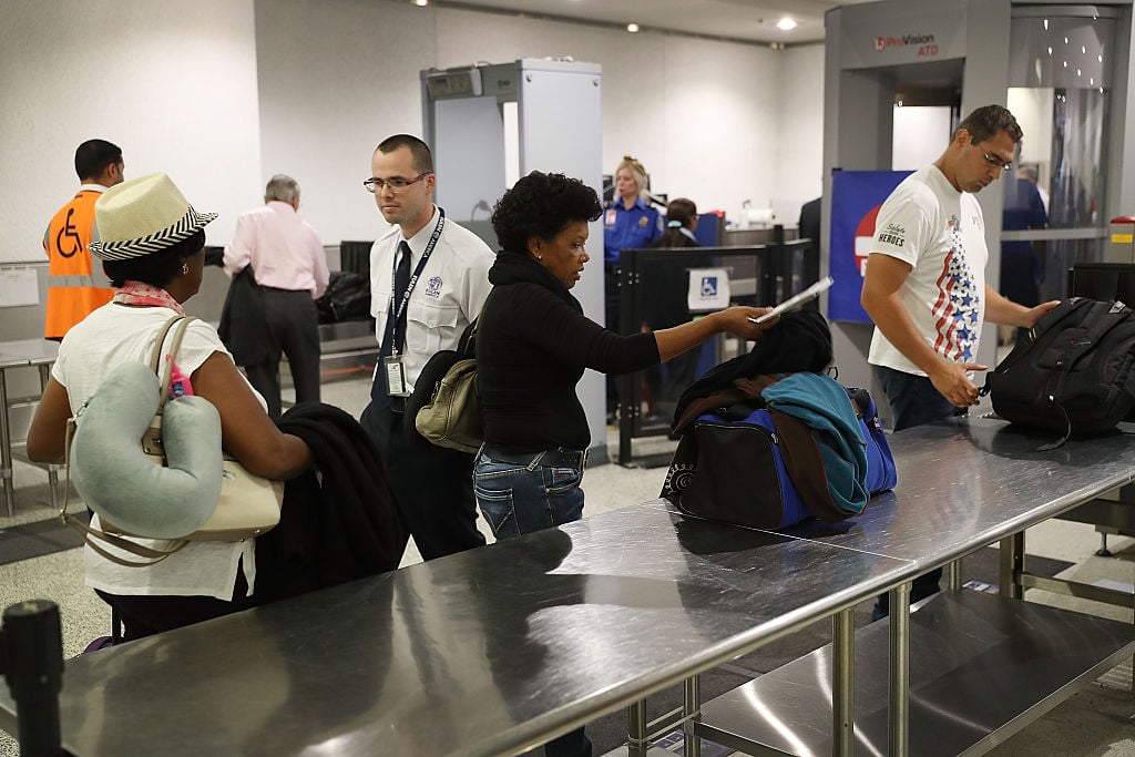 Travelers go through the TSA PreCheck security point at Miami International Airport