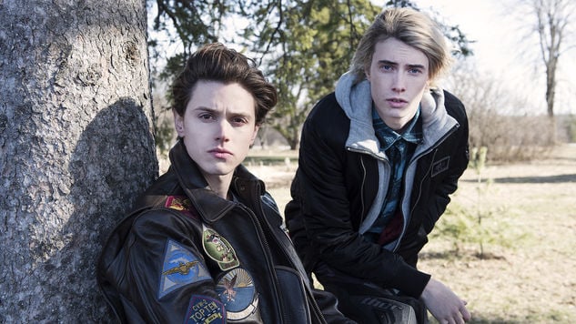 Tyler Young as Philip Shea and James Paxton as Lukas Waldenbeck sit in front of a tree in USA's Eyewitness