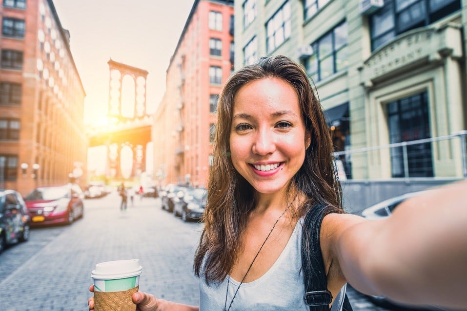 Woman taking selfie and writing selfie captions for Instagram