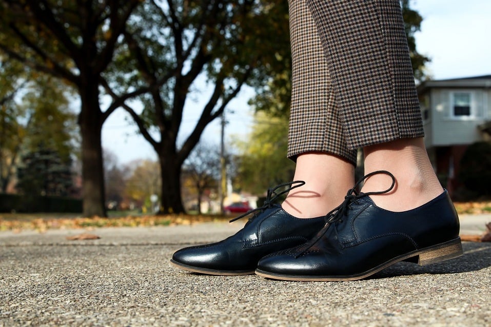 woman in fashion trousers standing in a classic fashion boots