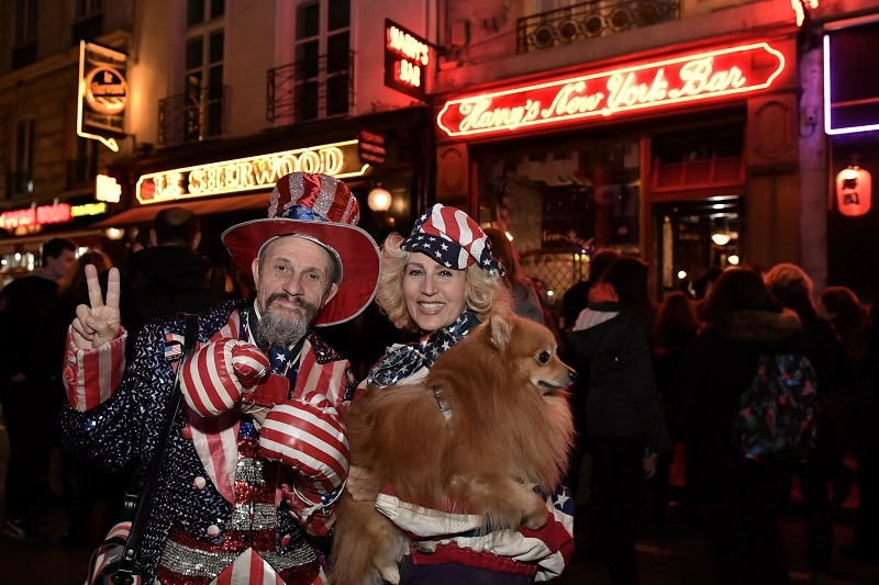 American expatriates who work abroad in France stand outside of an American bar in patriotic garb