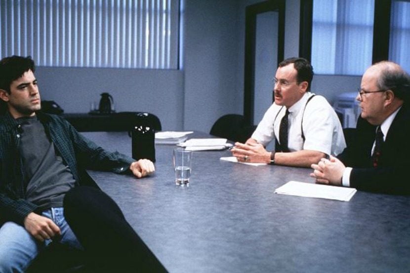 Peter Gibbons sits in an interview with consultants in the movie Office Space