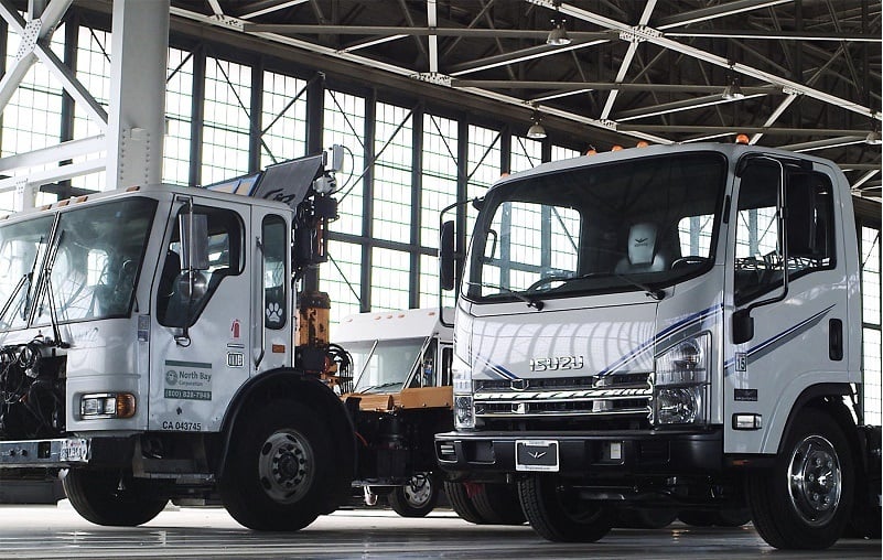 White Wrightspeed trucks sit parked in a garage