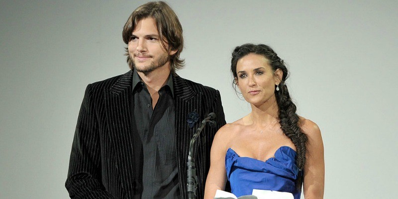 Demi Moore and Ashton Kutcher stand side by side at a podium. 