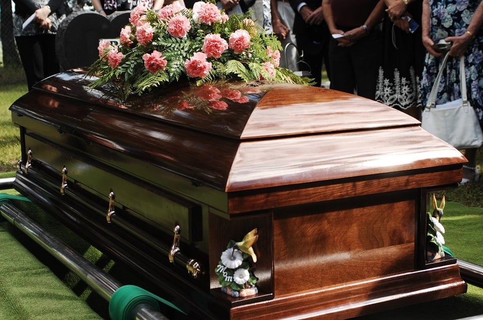 A coffin about to be lowered at a funeral service