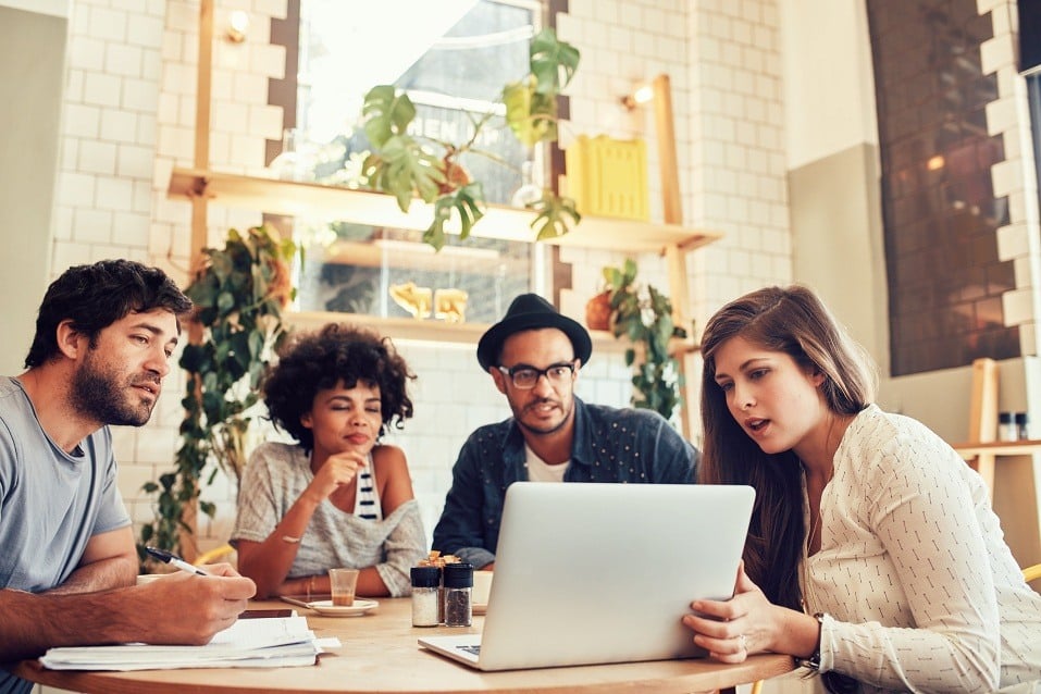 A young creative team sits at a cafe
