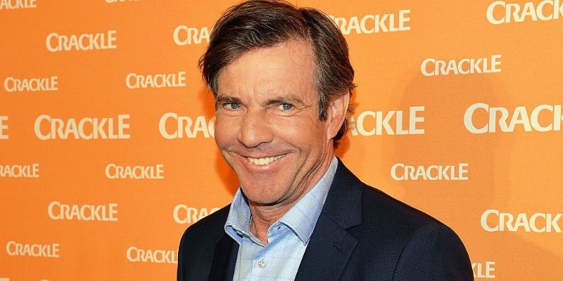 Dennis Quaid is smiling on the red carpet.