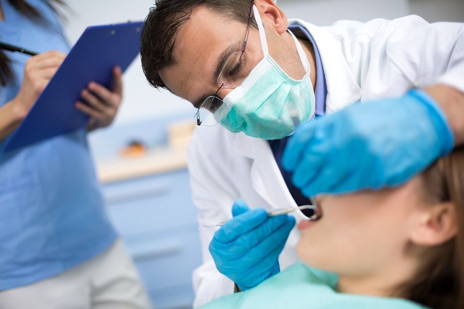 Dentist repairs tooth of his female patient