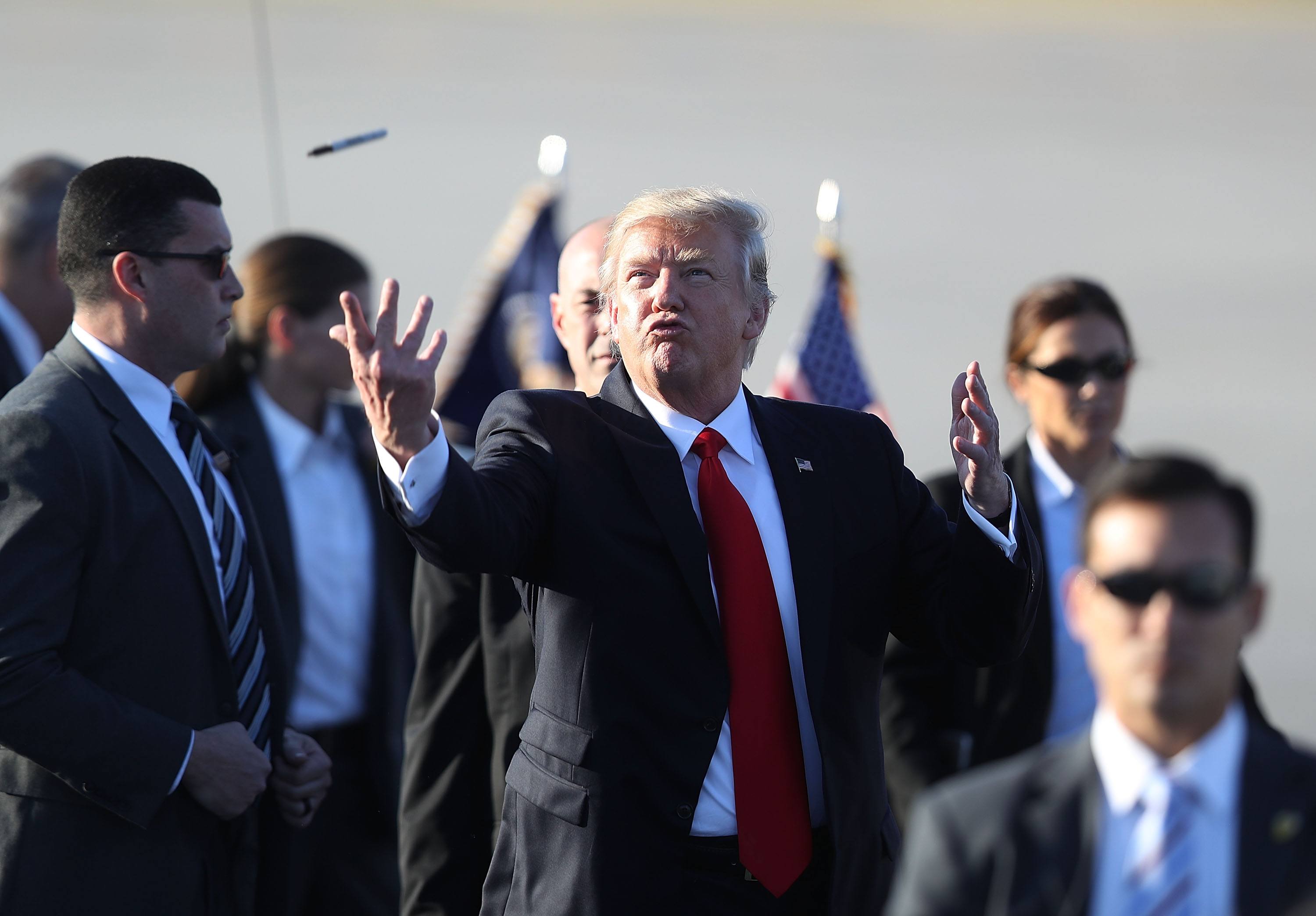 President Donald Trump tosses a sharpie pen that he was using for autographs
