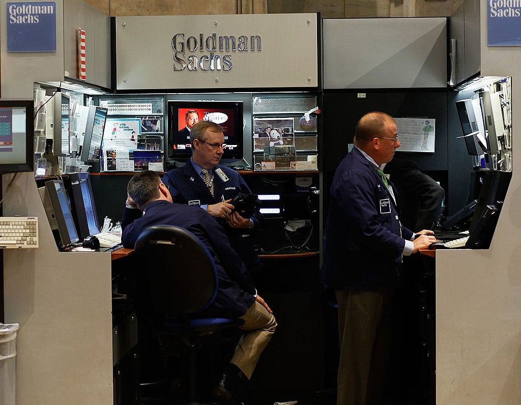 Financial professionals work in the Goldman Sachs booth on the floor of the New York Stock Exchange