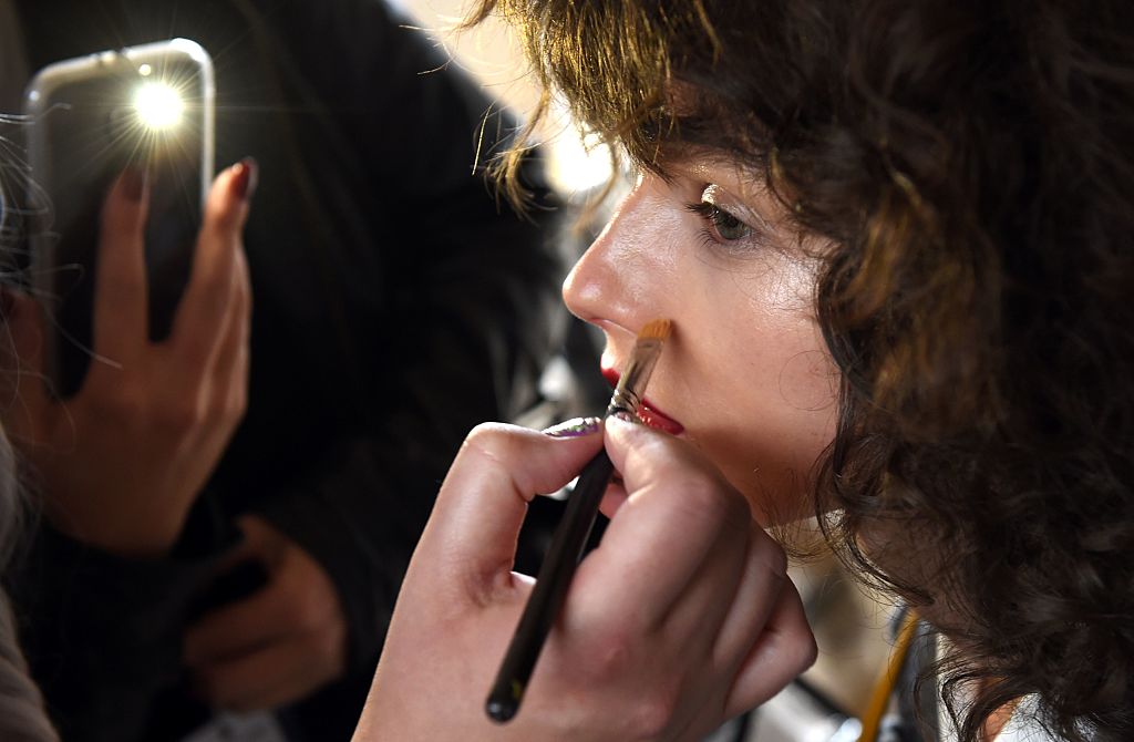 A model has her makeup attended to backstage before a showing of Australian designer