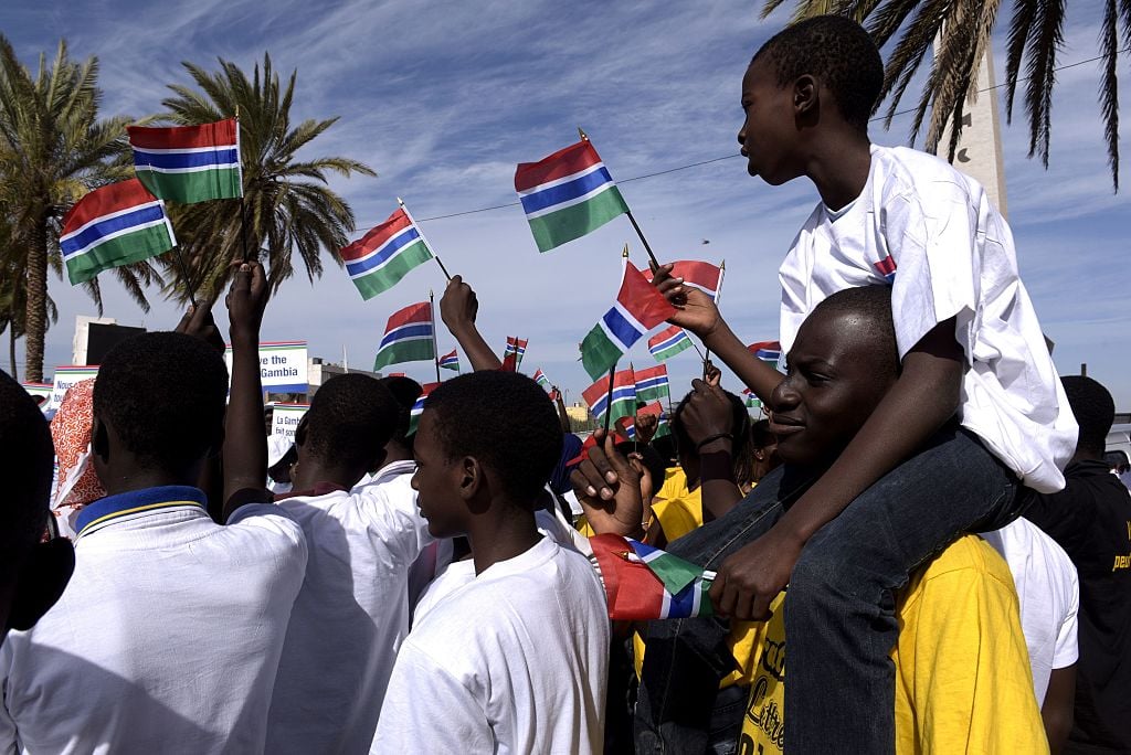 People wave Gambian flags during a protest