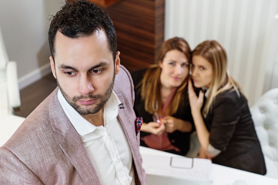 women whispering behind man's back
