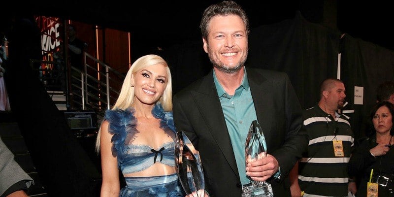 Blake Shelton and Gwen Stefani are smiling backstage at the People's Choice Awards and are holding their awards