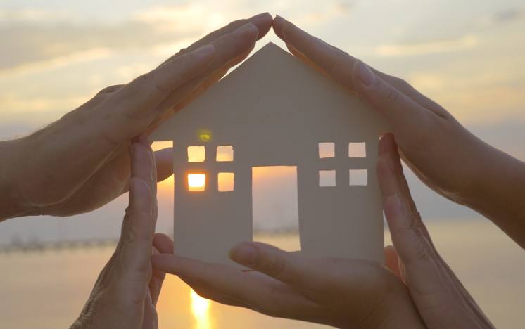 human palms on all sides of a cut out house diagram