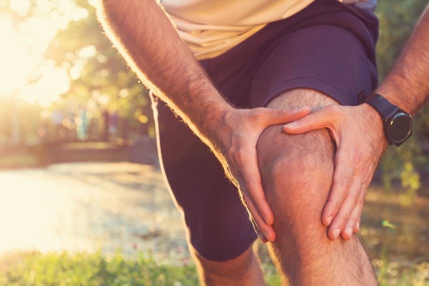 a man holding his knee from a jogging injury