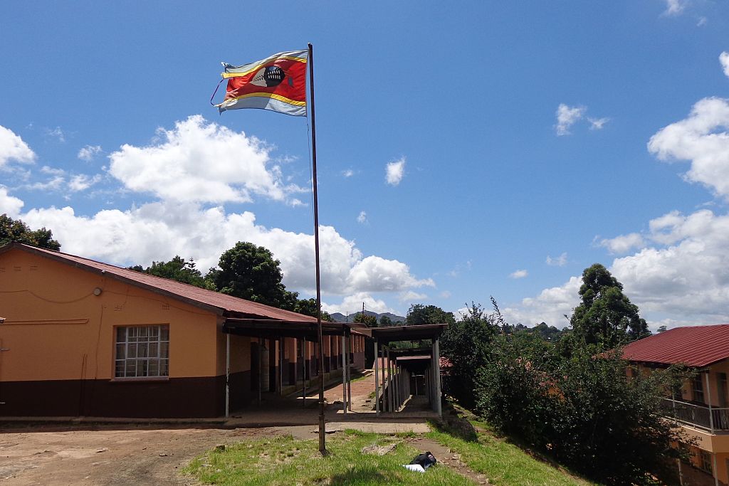 Kingdom of Swaziland flag flies on a mast by a public school