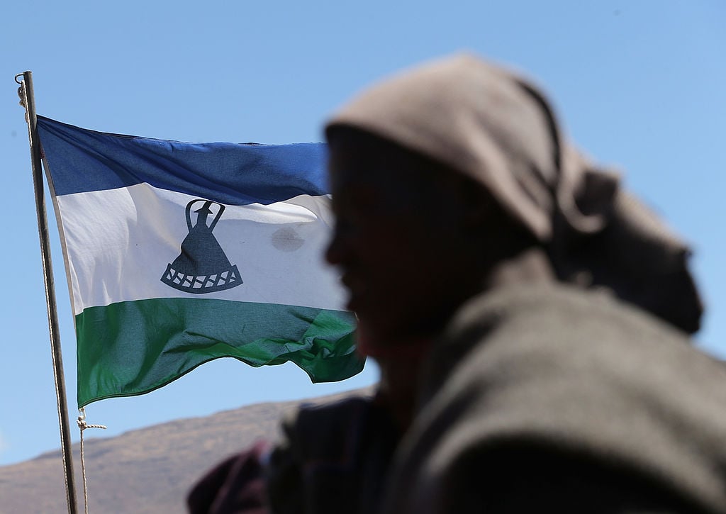 A herd boy in front of the Lesothan flag