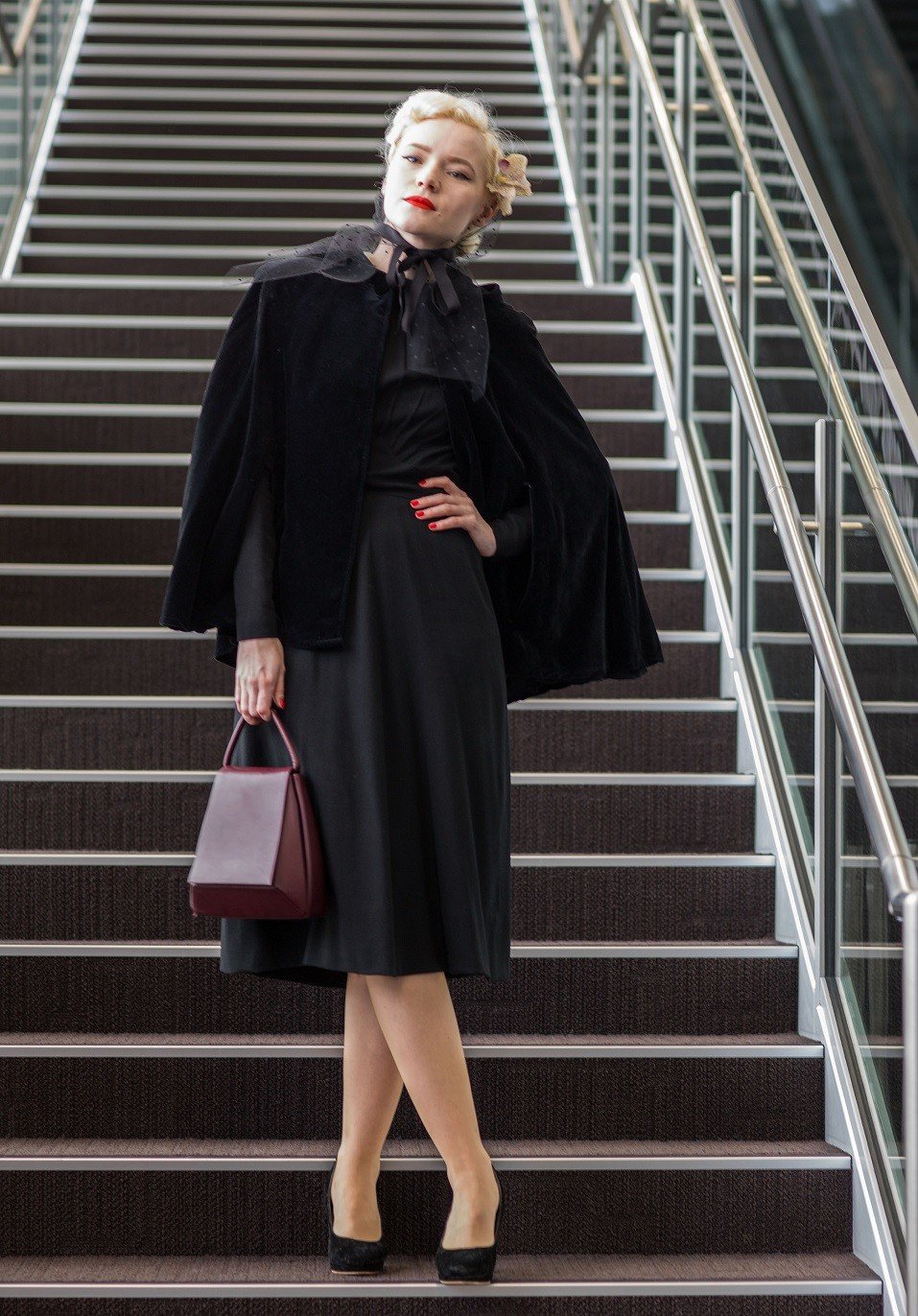 A guest is seen wearing vintage cape and dress