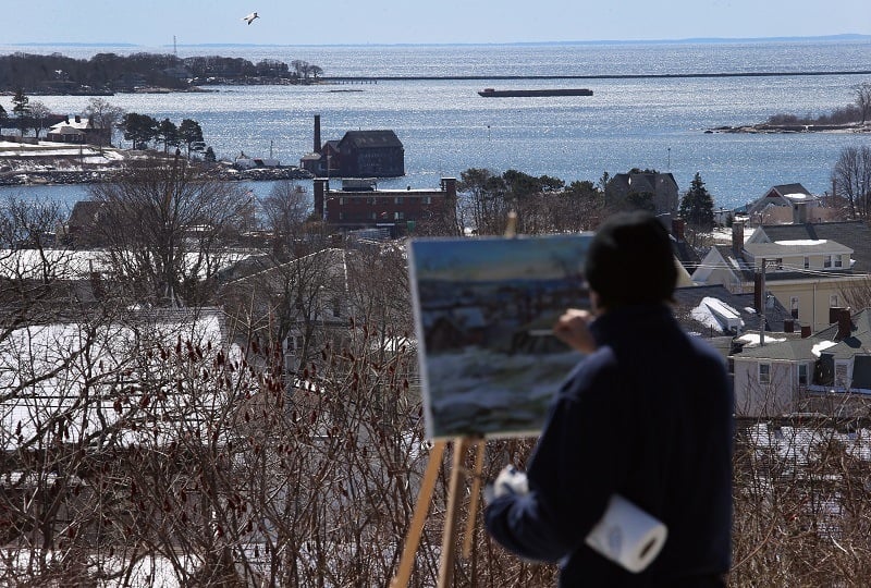 An artist paints the Gloucester Harbor in Massachusetts