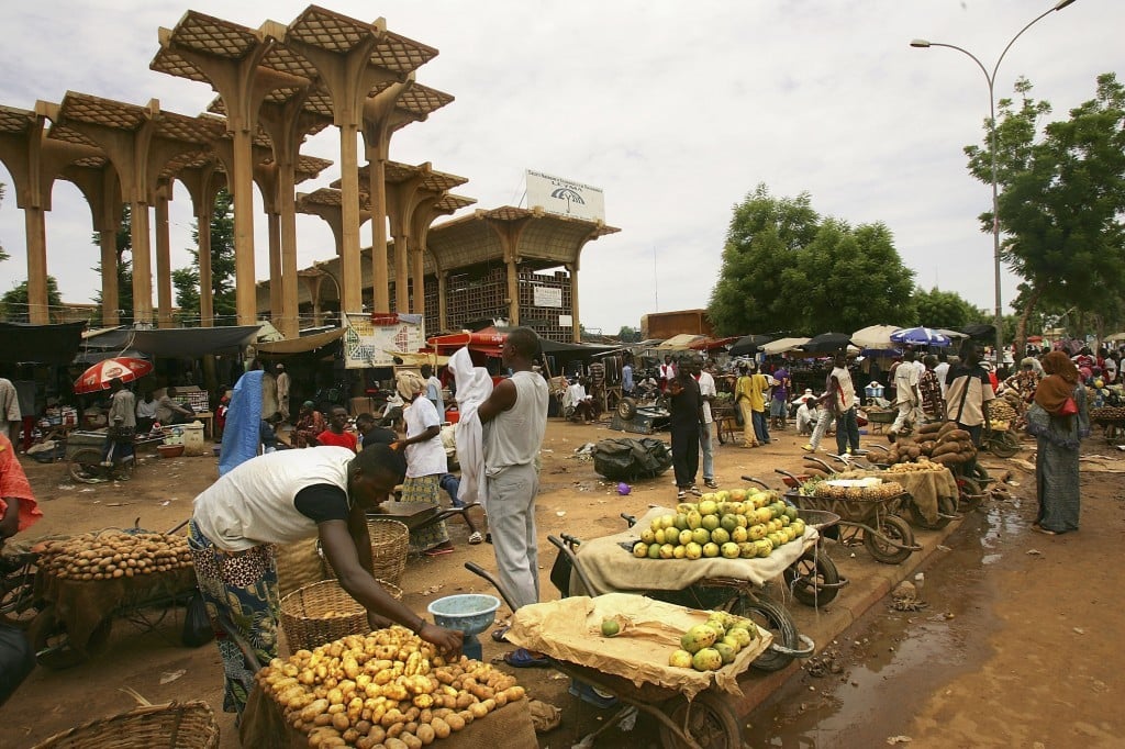 A Nigerois man rearranges his produce at the central Niamey marketplace