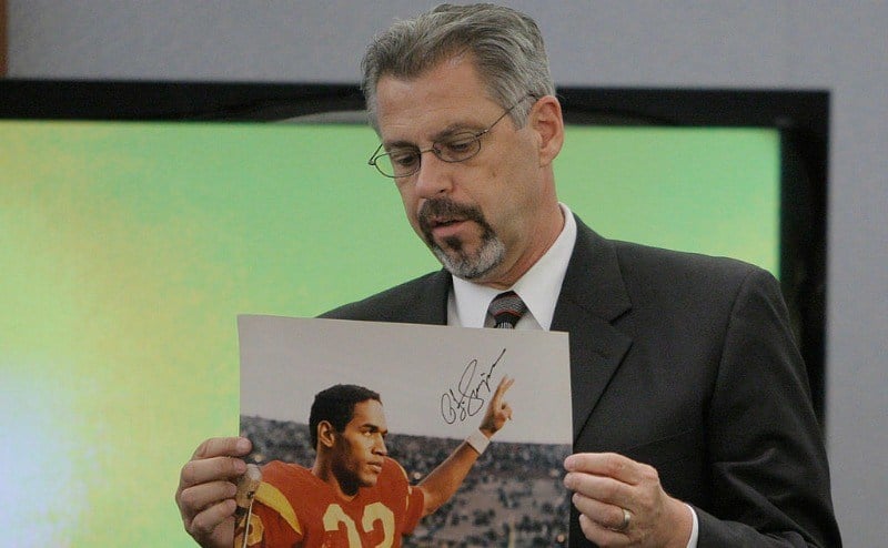 Prosecution opening witness Bruce Fromong displays a signed photo that was entered into evidence