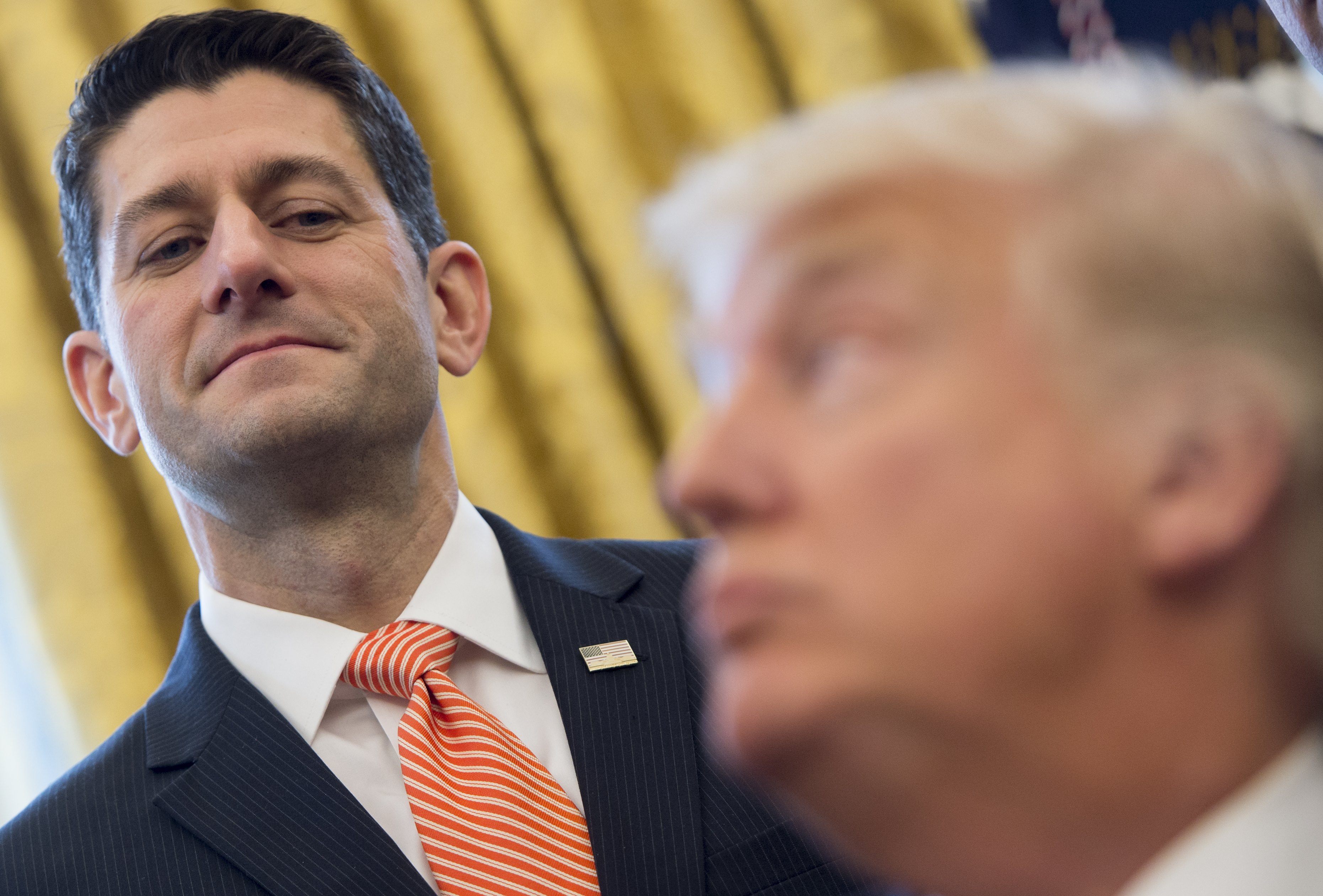 Speaker of the House Paul Ryan lords over President Donald Trump after signing House Joint Resolution 41, which removes some Dodd-Frank regulations on oil and gas companies