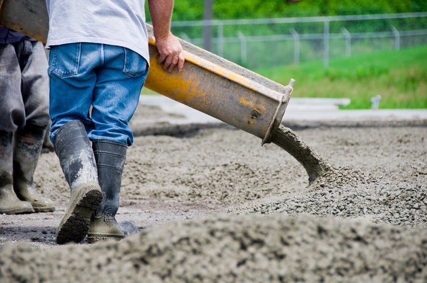 A man is seen pouring cement