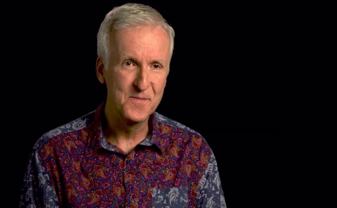 James Cameron is wearing a patterned shirt and talking to the camera.