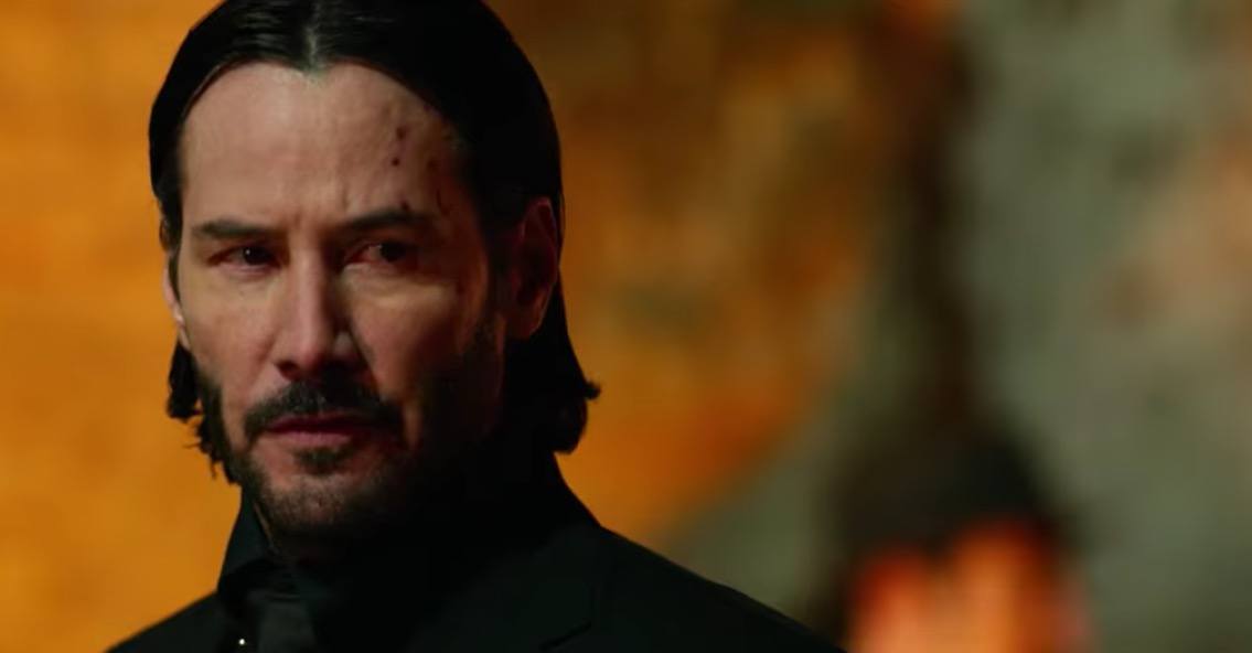A close-up on John Wick, as he glances to the right of the frame A close-up on John Wick, as he glances to the right of the frame