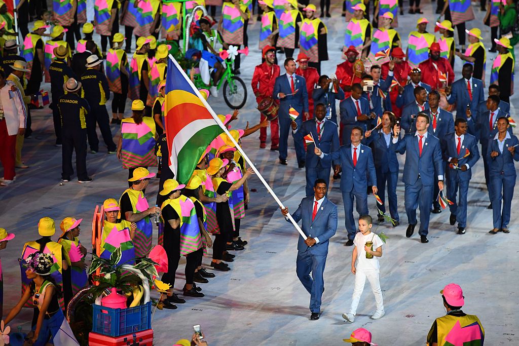 Seychelles' flag bearer Rodney Govinden leads his national delegation