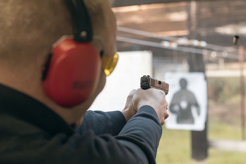 Man aiming pistol at a target in a shooting range