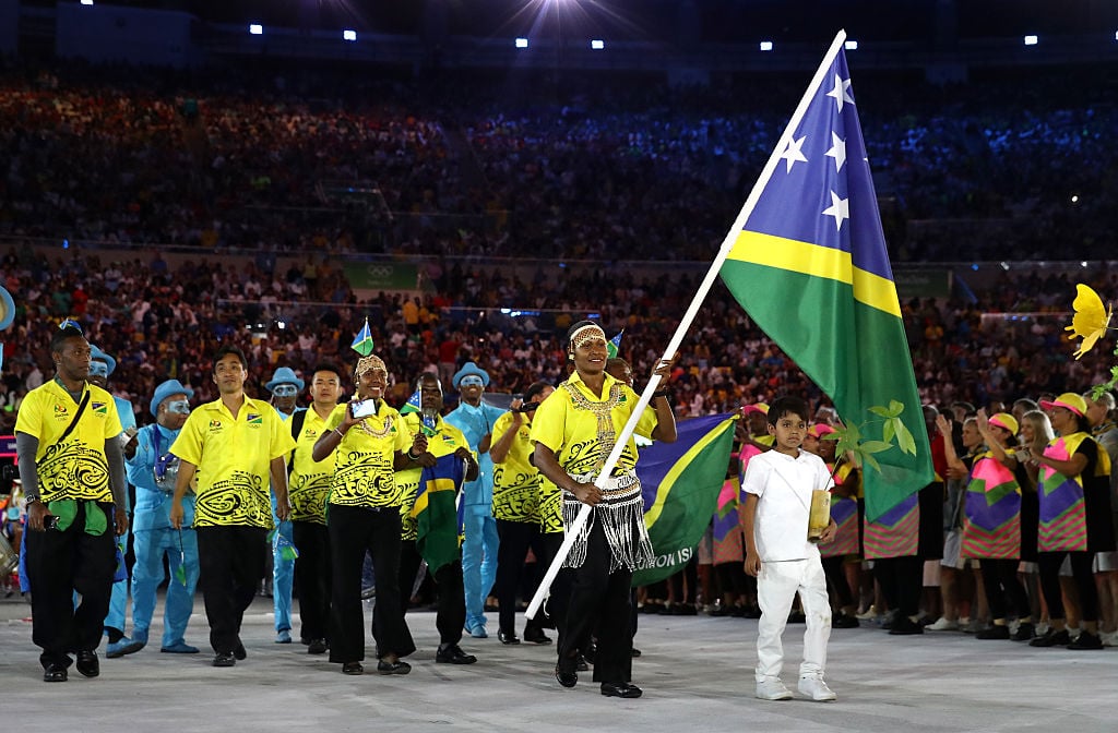 Jenly Wini of the Solomon Islands carries the flag